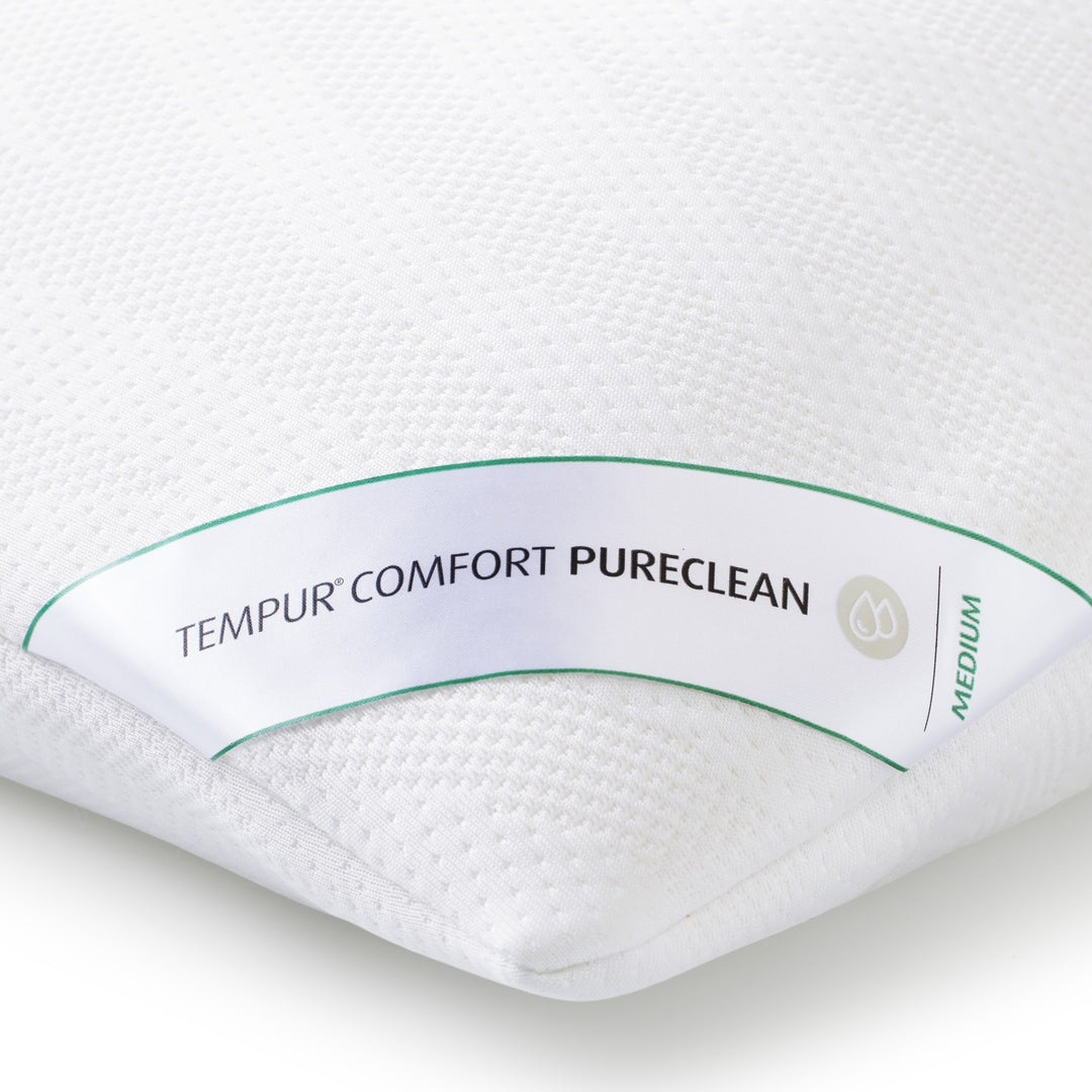 Nærbilde av etiketten Tempur Comfort PureClean på hvit hodepute, fasthet medium