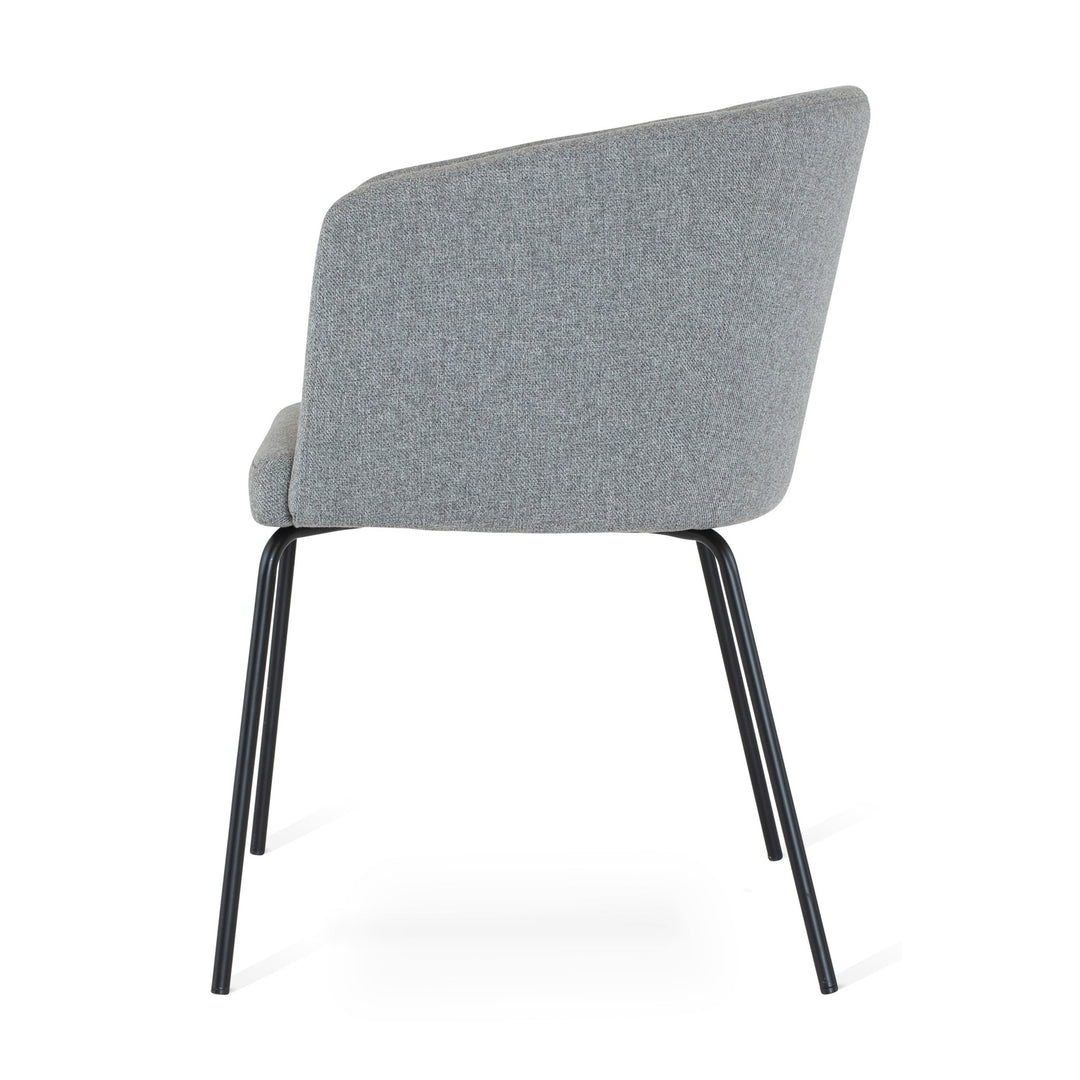 Fab spisestol i grått stoff med buet rygg og sorte ben, sett fra siden mot hvit bakgrunn