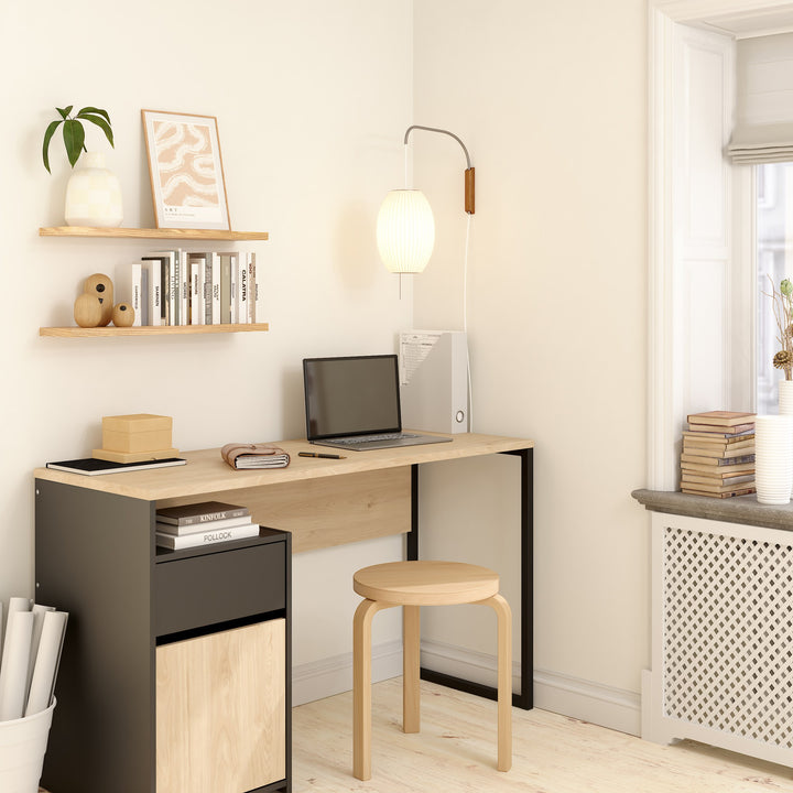 Function Plus 1 skrivebord i eik med sort ramme i hjemmekontor med laptop, bøker og krakk