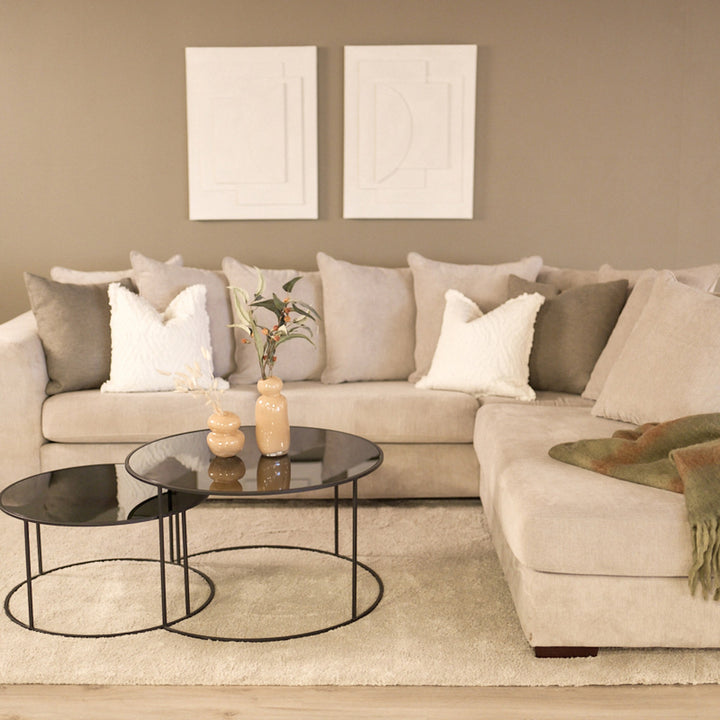 Havanna hjørnesofa i lys beige i stue med beige vegg, sorte rundbord og grønt pledd