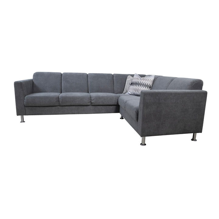 Korfu hjørnesofa i mørk grå stoff med krombein og mønstret pute.