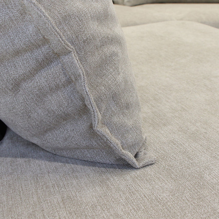 Justin hjørnesofa i beige stoff, nærbilde av pute som hviler på setet