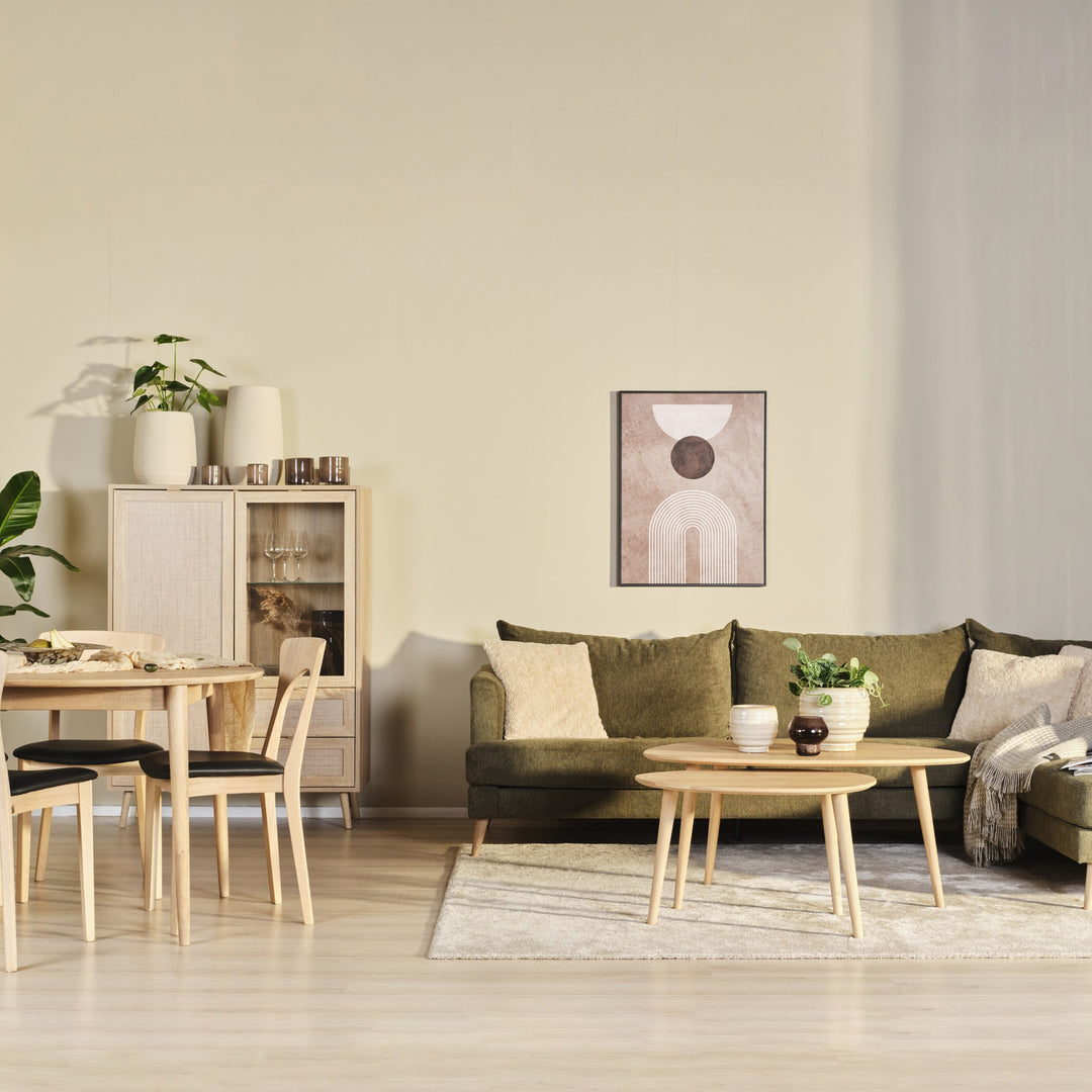 Justin hjørnesofa i olivengrønn stoff i stue med spisebord, trekommode og grønne planter