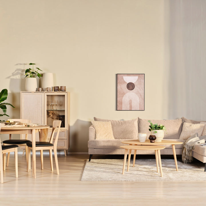 Justin hjørnesofa i beige stoff i lys stue med spisebord, trekommode og sofabord