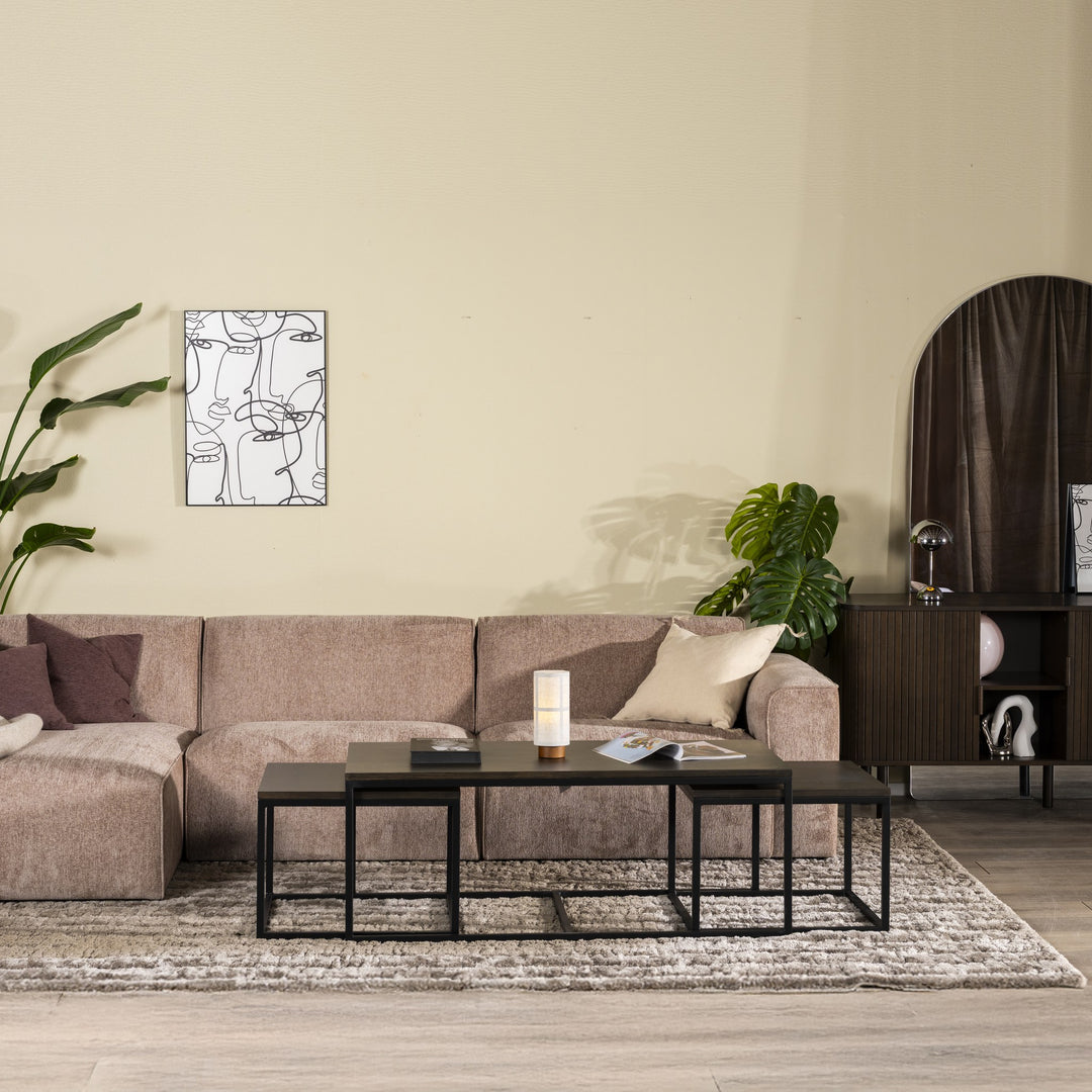 Como hjørnesofa i gråbeige chenille i stue med monstera, mørk kommode og sorte sofabord