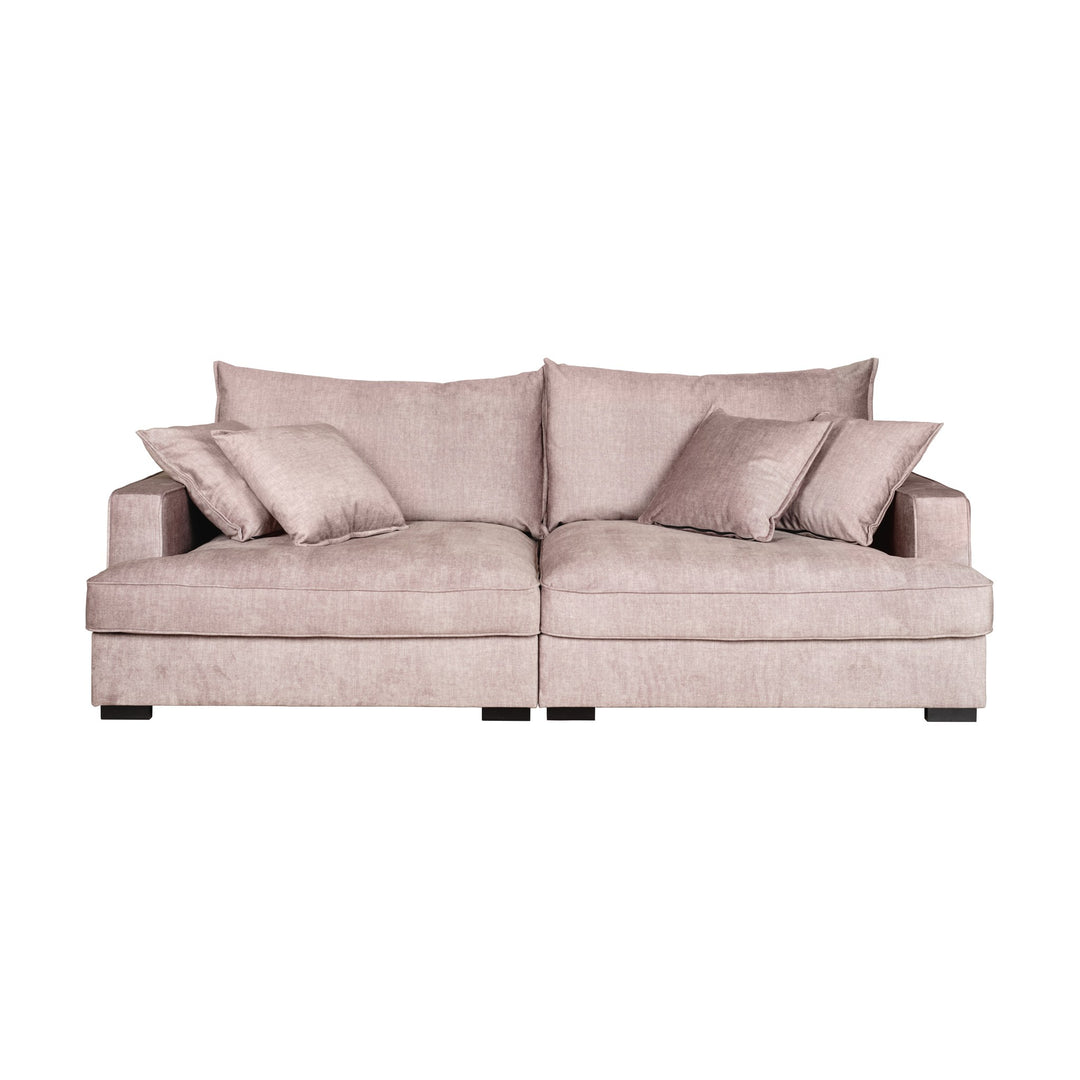 Rossi sofa i beige velur med løse puter, sett skrått forfra mot hvit bakgrunn