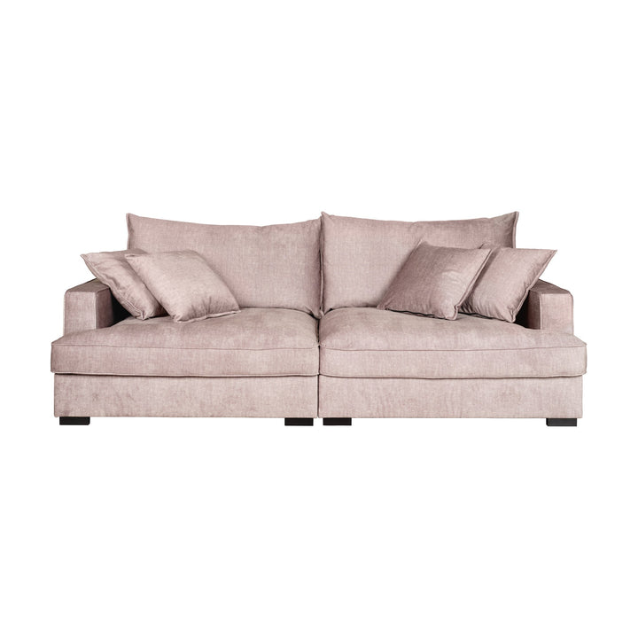 Rossi sofa i beige velur med løse puter, sett skrått forfra mot hvit bakgrunn