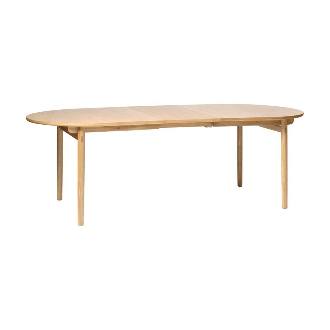 Carno spisebord i eik, ovalt med ilagt plate, sett skrått mot hvit bakgrunn