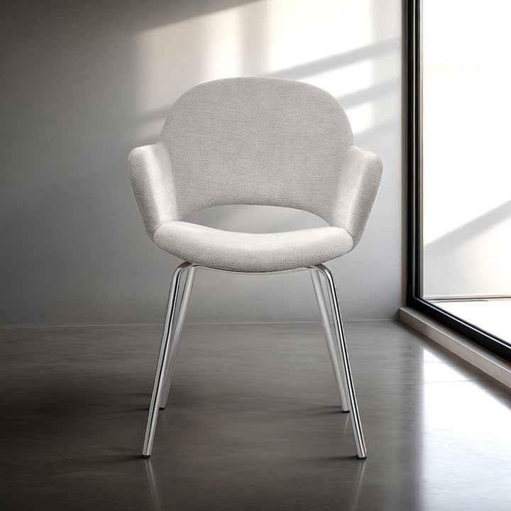 Rowley spisestol i lys beige vevd stoff med blanke krombein i minimalistisk betongrom ved vindu