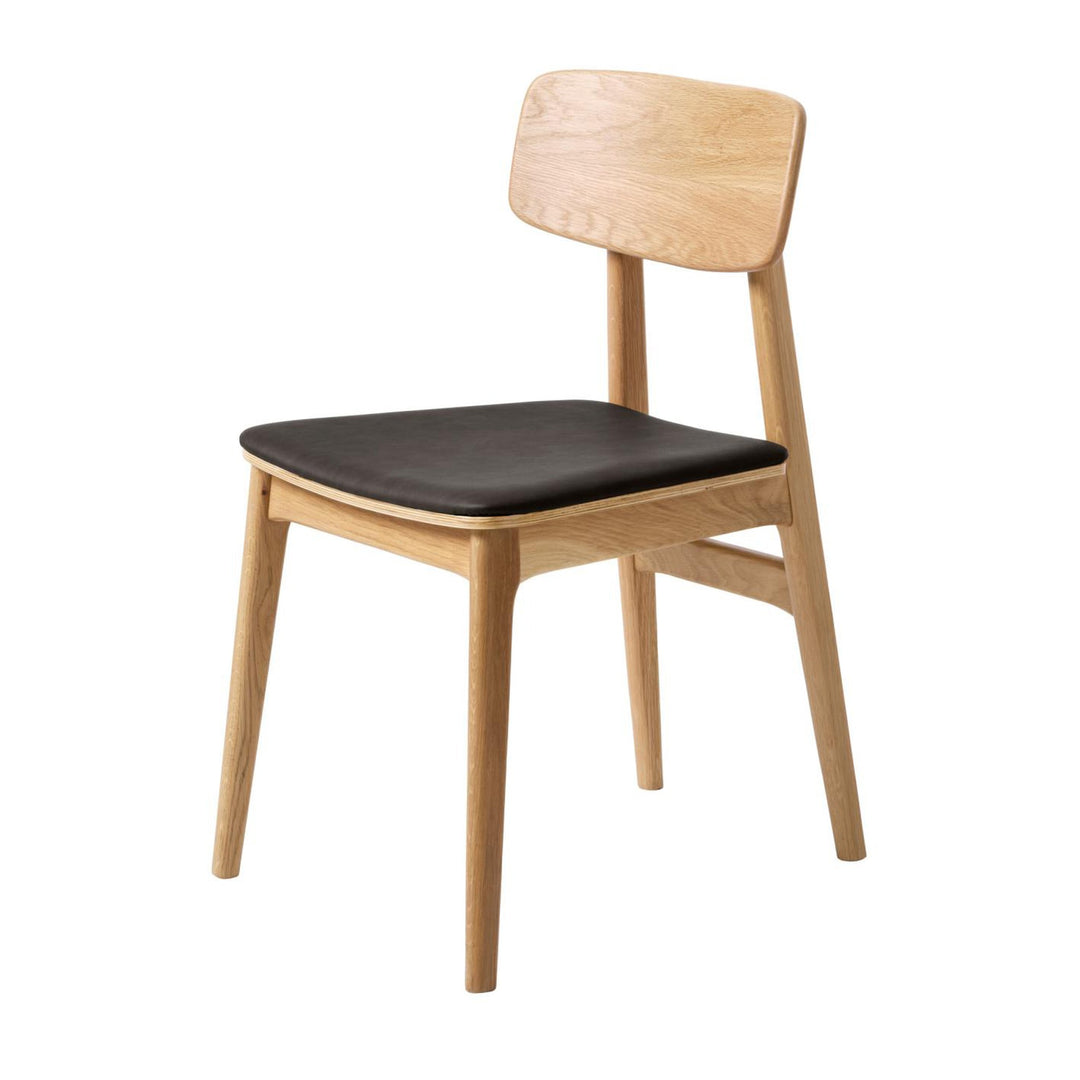 Livo spisestol i lys eik med sete i sort kunstskinn, sett skrått forfra