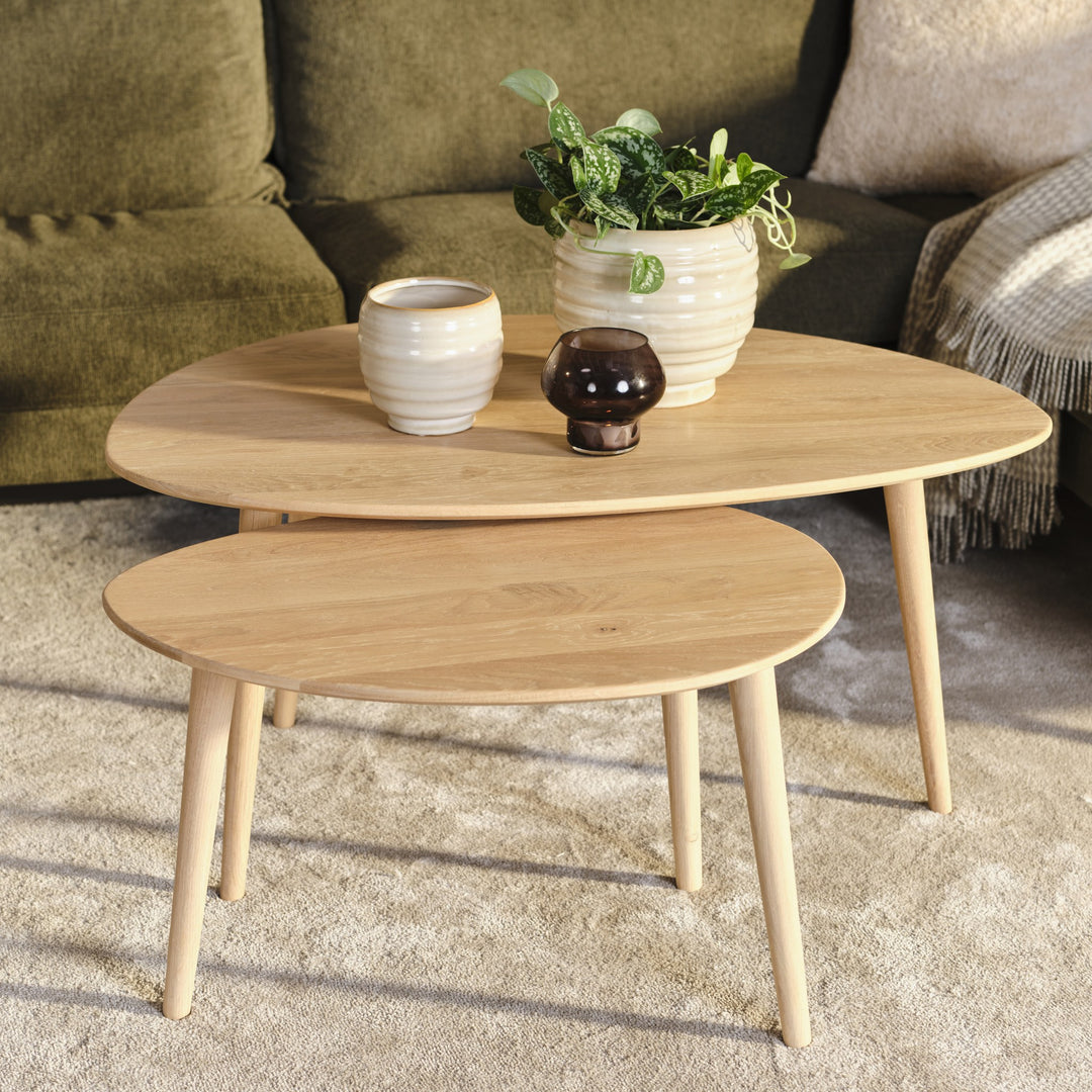 Sverre sofabord i lys natureik, to bord foran grønn sofa med plante og kopper