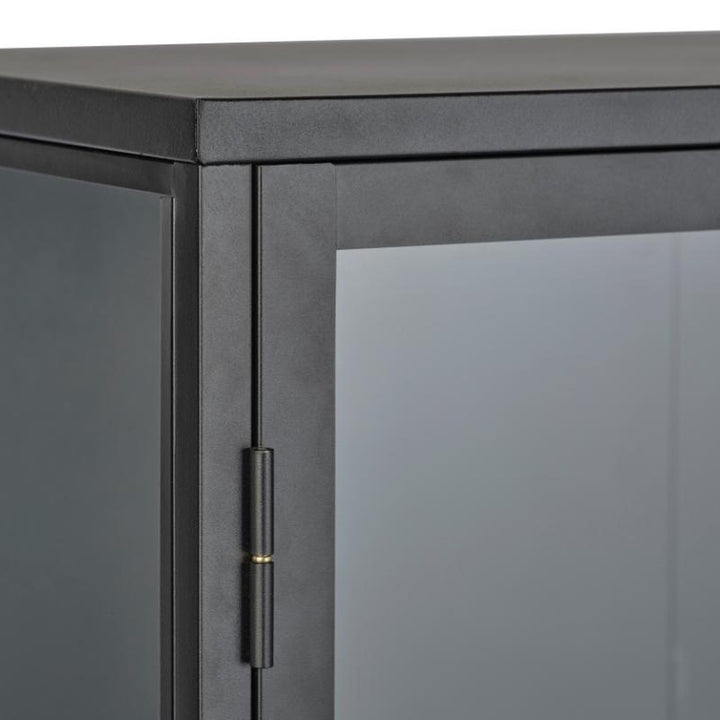 Carmel skap i sort, detalj av øvre hjørne med metallramme, glass og hengsel med messingdetalj