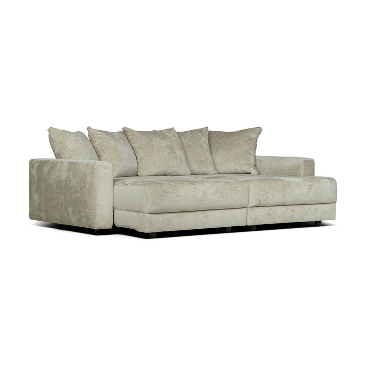 Bellus Glory sovesofa i lys beige chenille med flere ryggputer, sett forfra på hvit bakgrunn