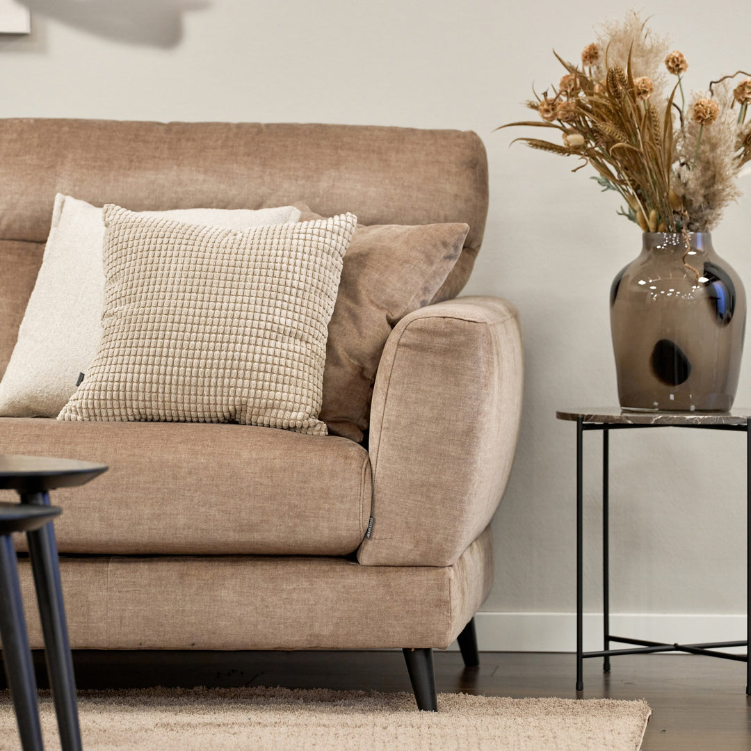 Bellus Robin sofa i gråbeige stoff med stripepute og brun glassvase med tørrblomster