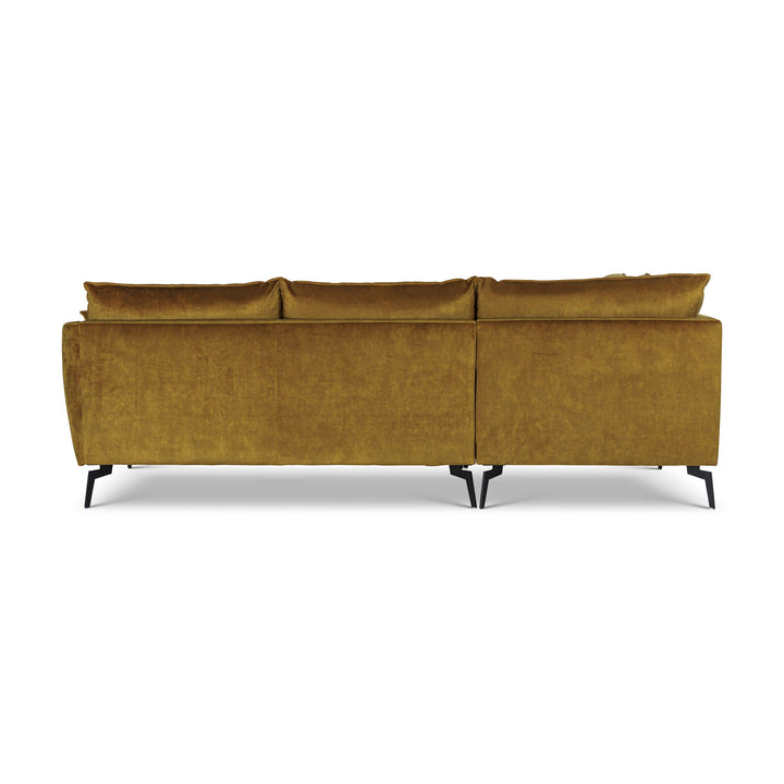 Bellus Coral hjørnesofa i okergul velur med sorte metallben, sett bakfra på hvit bakgrunn