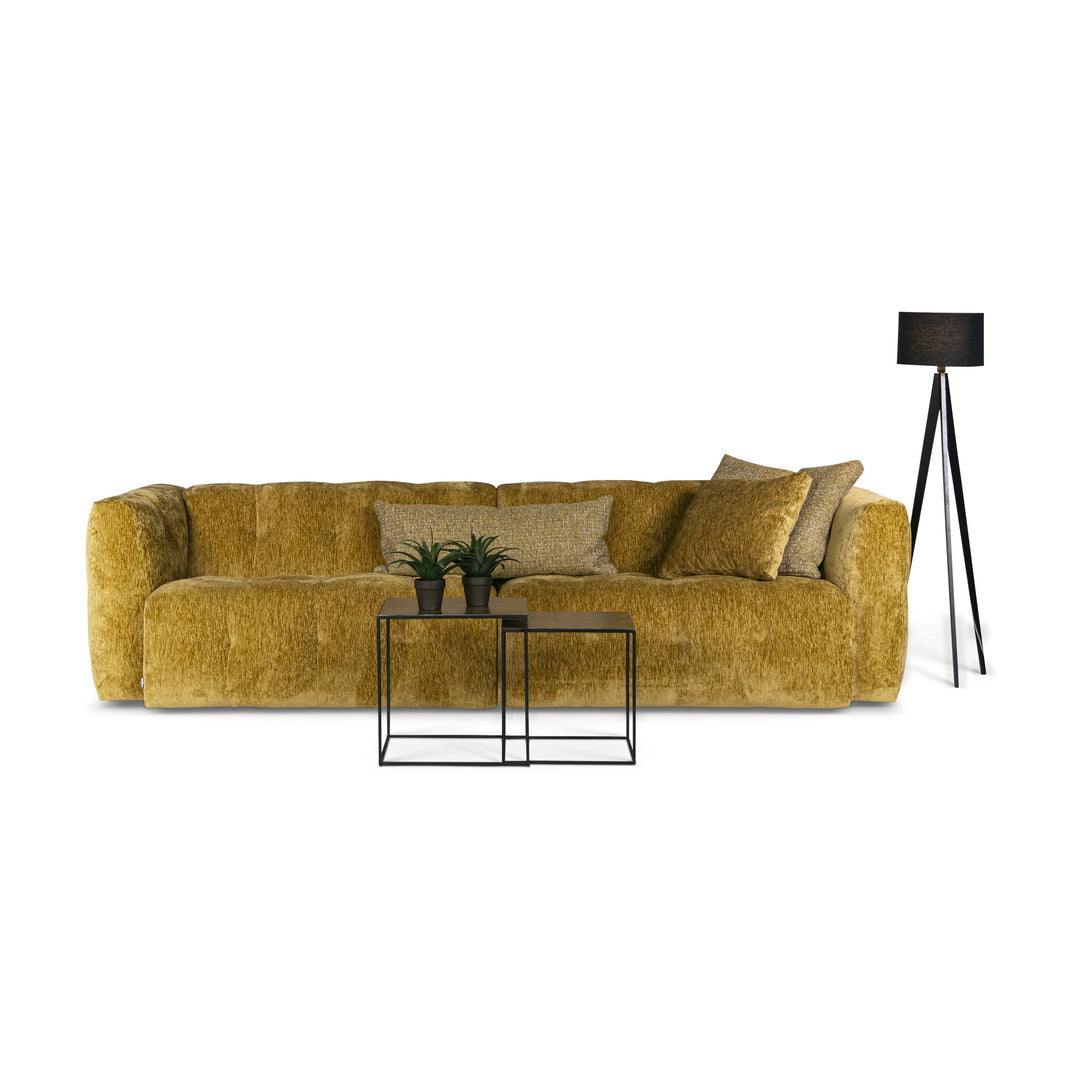 Bellus Soffy sofa i okergul chenille med svart gulvlampe, settbord og grønne planter