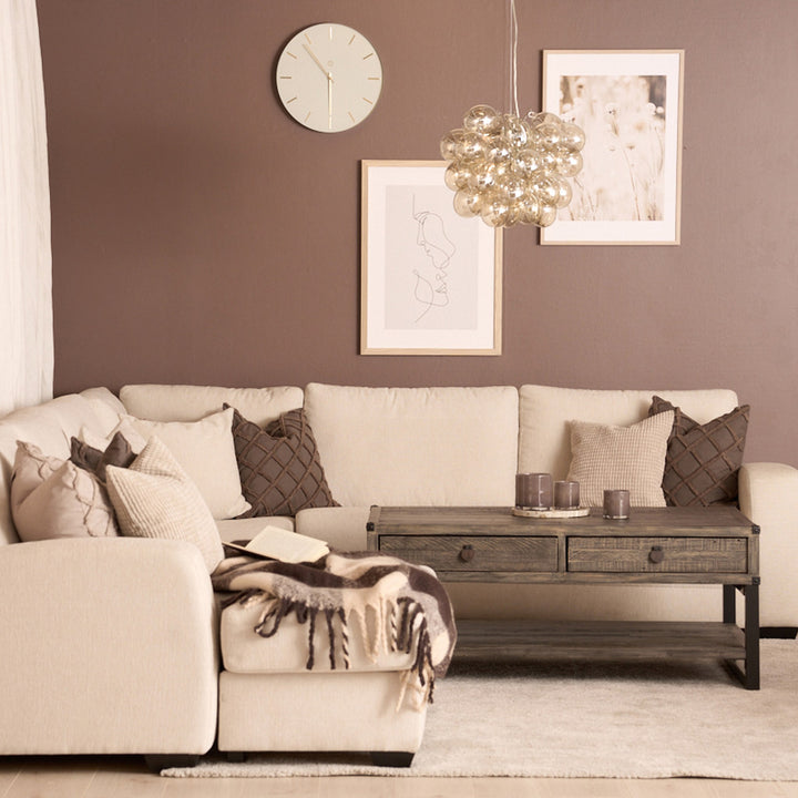 Bellus Casino modulsofa i beige i stue med brun vegg, trebord og pynteputer