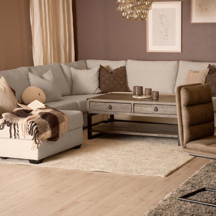 Bellus Casino modulsofa i beige i stue med brun lenestol, trebord og brun vegg