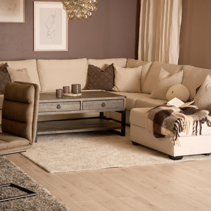 Bellus Casino modulsofa i beige i stue med brun lenestol, trebord og pledd