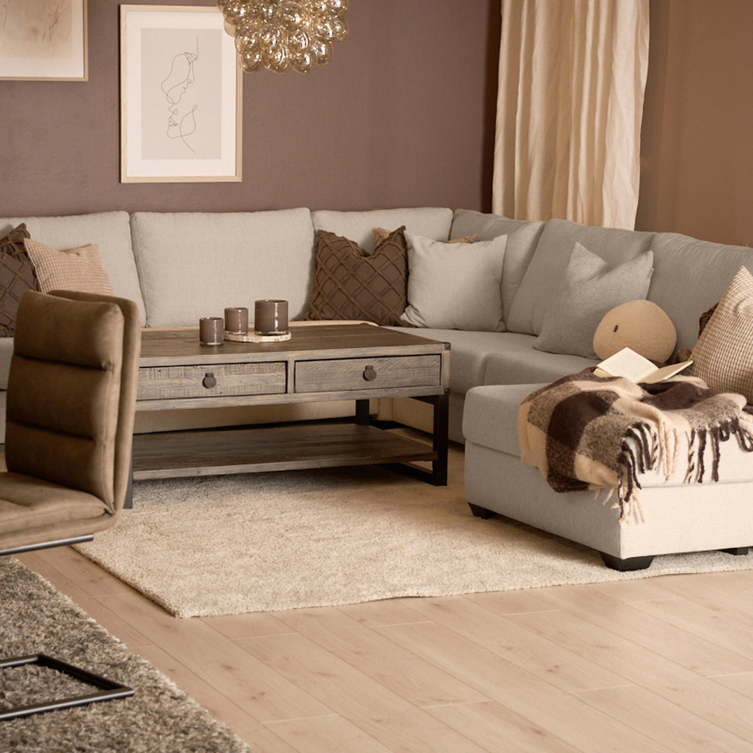 Bellus Casino modulsofa i beige i stue med brun lenestol og rustikk trebord
