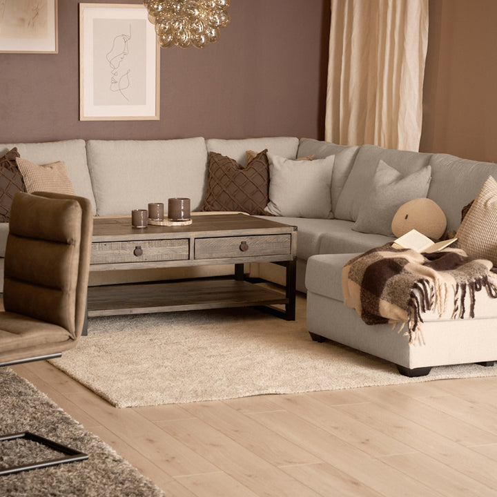 Bellus Casino modulsofa i beige i stue med brun lenestol og rustikk trebord