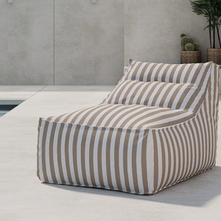 Venture Design Redang loungestol i beige og hvit stripet stoff, ved basseng med betongvegg og kaktus