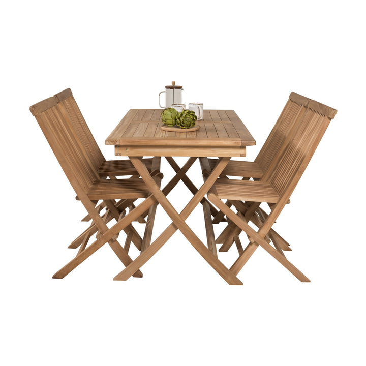 Venture Design Kenya spisebord i teak med to klappstoler, kaffepresse og artisjokker på fat.