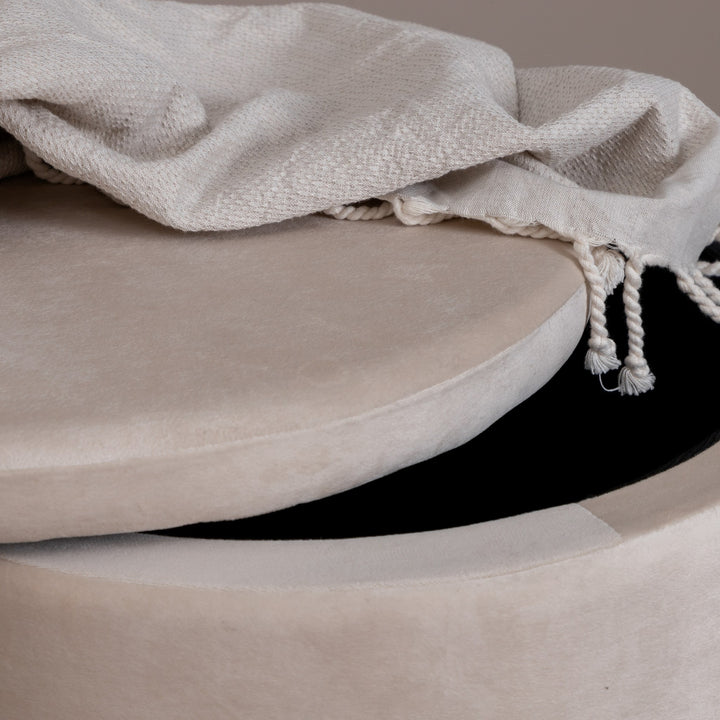Dunken puff i beige velur, nærbilde av lokket på gløtt med pledd og sort oppbevaringsrom.