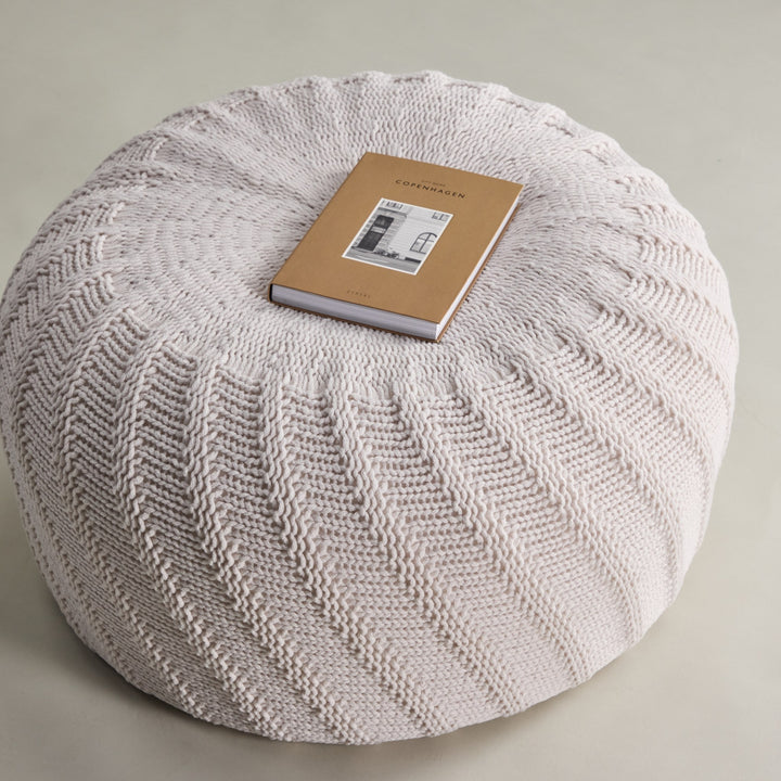 Ted puff i offwhite, sett ovenfra med spiralstrikk og bok på toppen.