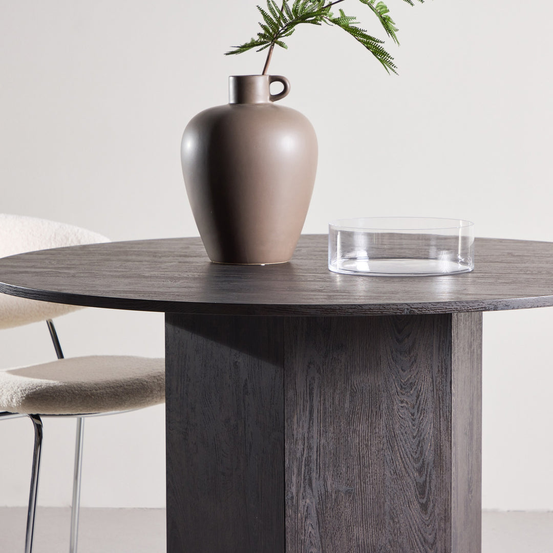 Tekla spisebord i sortbeiset tre med mørk vase og glasskål, offwhite boucléstol