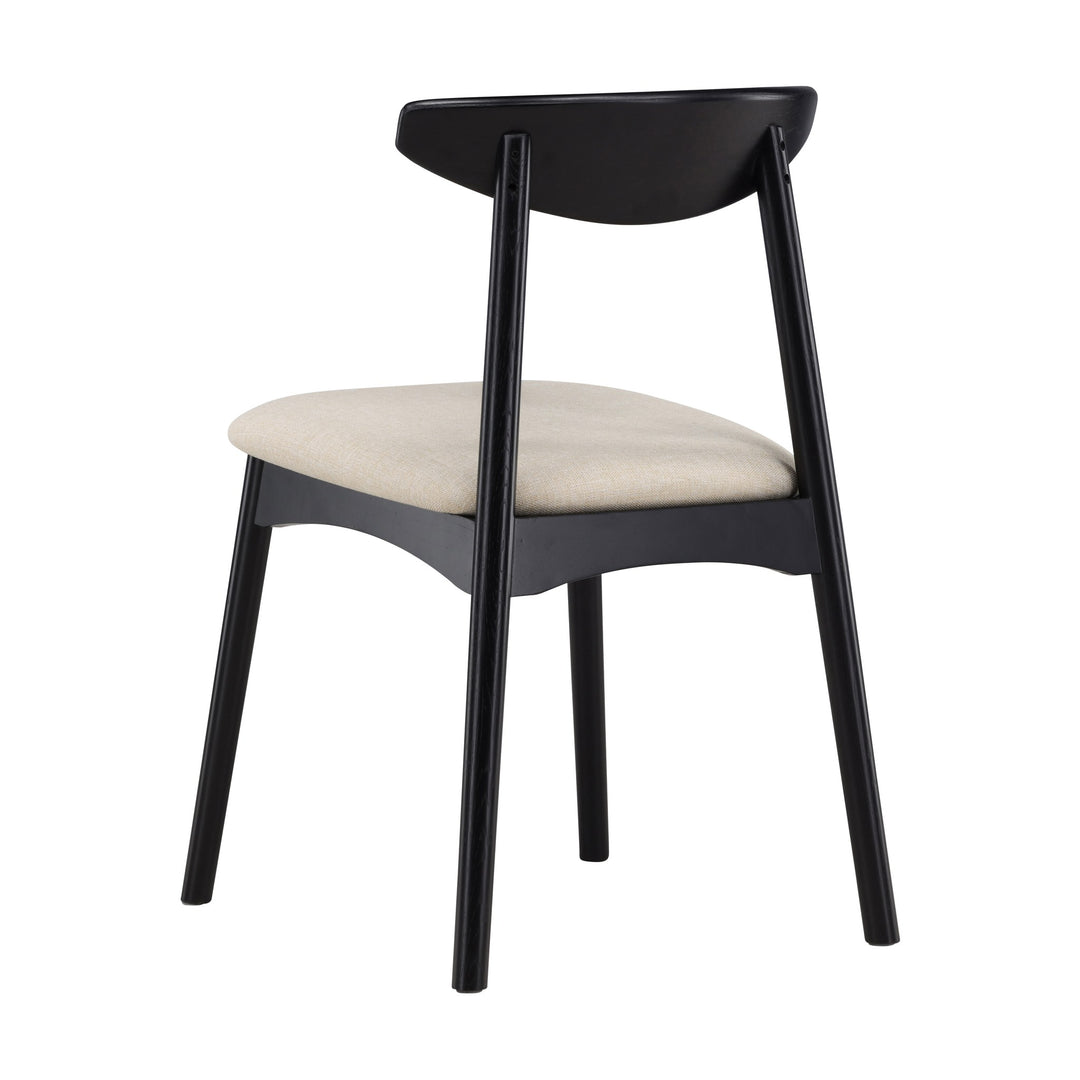 Ven spisestol i sort eik med beige sete, sett skrått bakfra mot hvit bakgrunn.