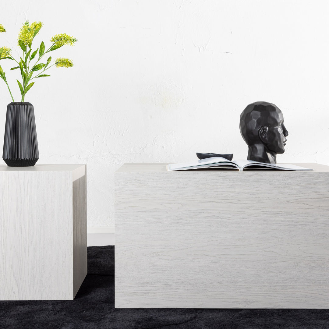 York sofabord i hvit whitewash-eik, i rom med sort vase med gule blomster og hodeskulptur