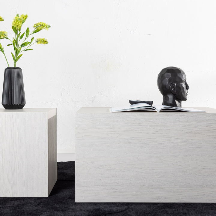 York sofabord i hvit whitewash-eik, i rom med sort vase med gule blomster og hodeskulptur