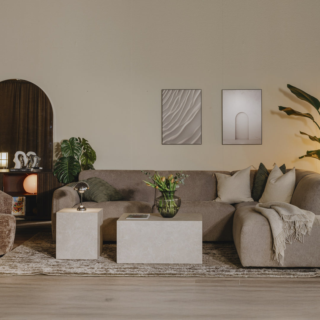 York sofabord i beige marmorlook, to kubebord i stue med beige sofa, planter og kunst