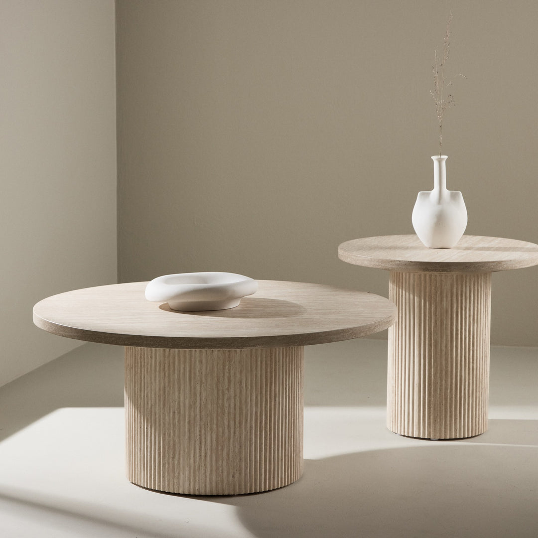 Harøn sidebord i lys travertin med hvit skål og vase, i lyst rom med beige vegg