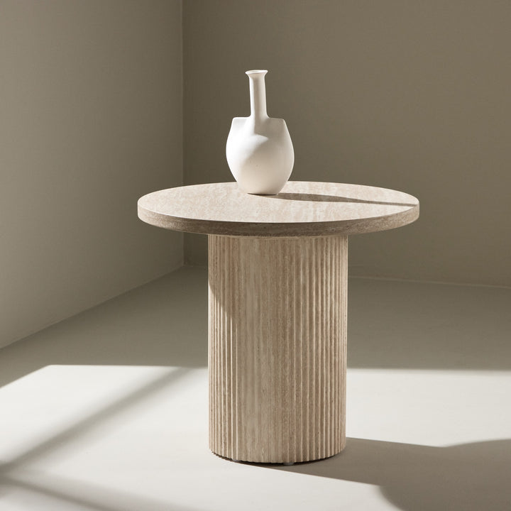Harøn sidebord i beige travertin, rundt med riflet søyleben og hvit vase
