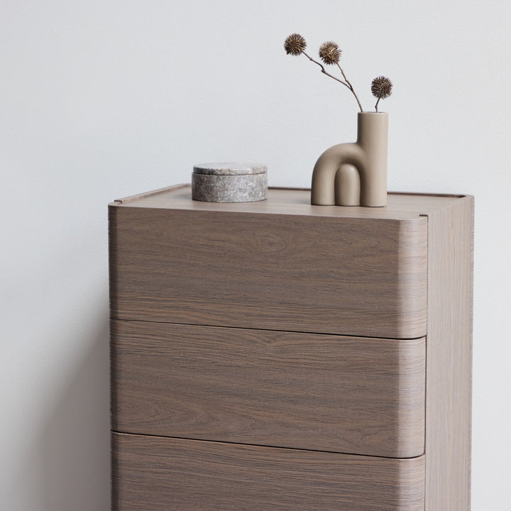 Noble kommode i gråbrun eik med marmorskrin og beige vase med tørket gren på toppen, mot hvit vegg