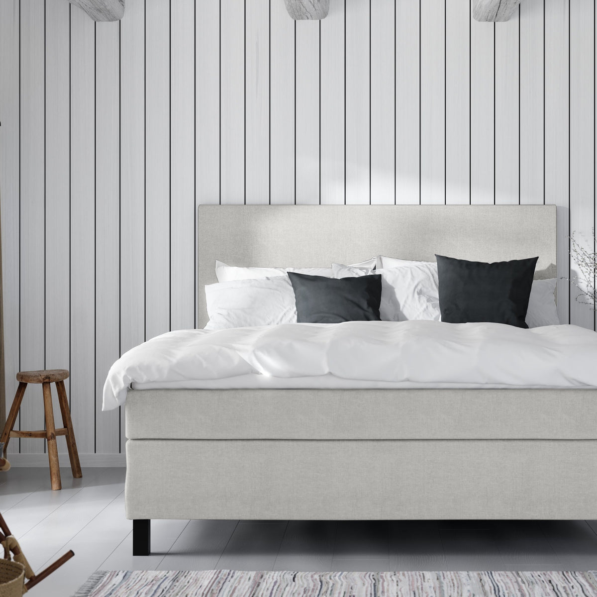Wonderland W50 sengegavl i lys beige stoff, mot hvit panelvegg med mørke puter