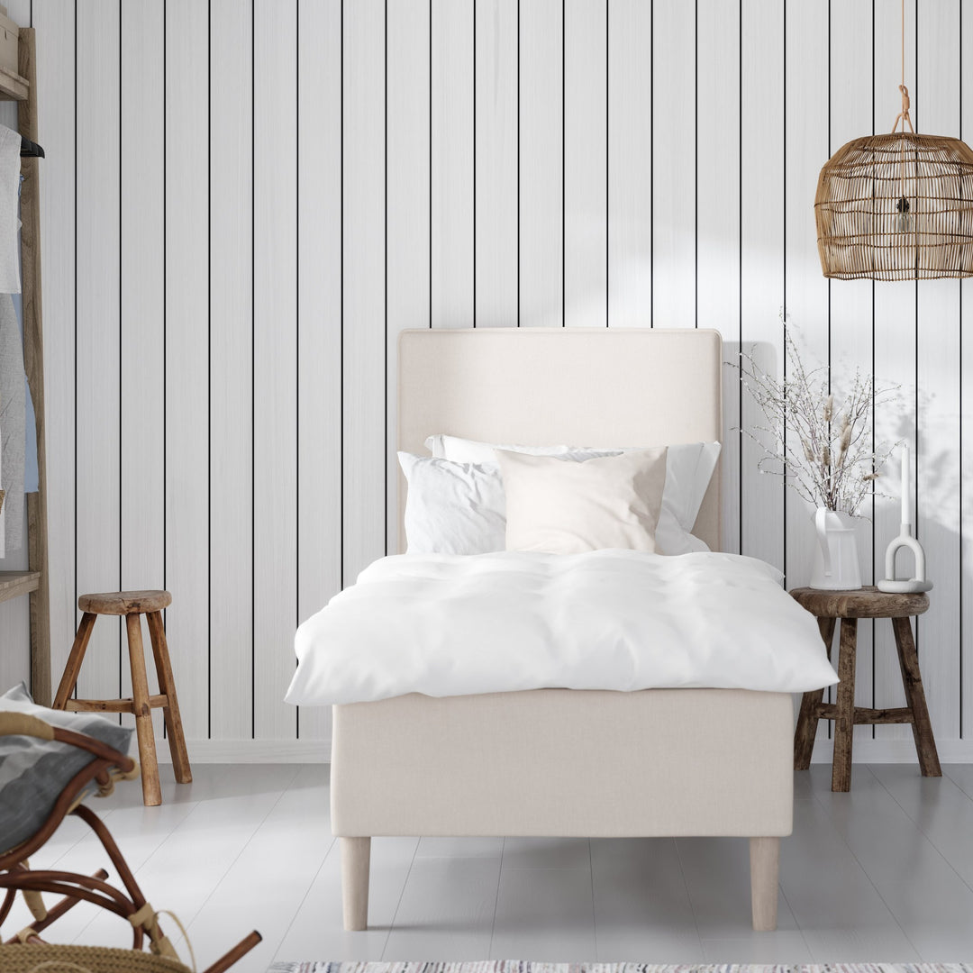 Wonderland Lento rammeseng i offwhite stoff med hvitt sengetøy i lyst rom med rottinglampe