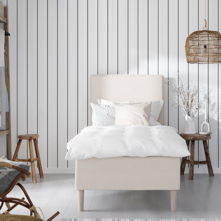 Wonderland Lento rammeseng i offwhite stoff med hvitt sengetøy i lyst rom med rottinglampe