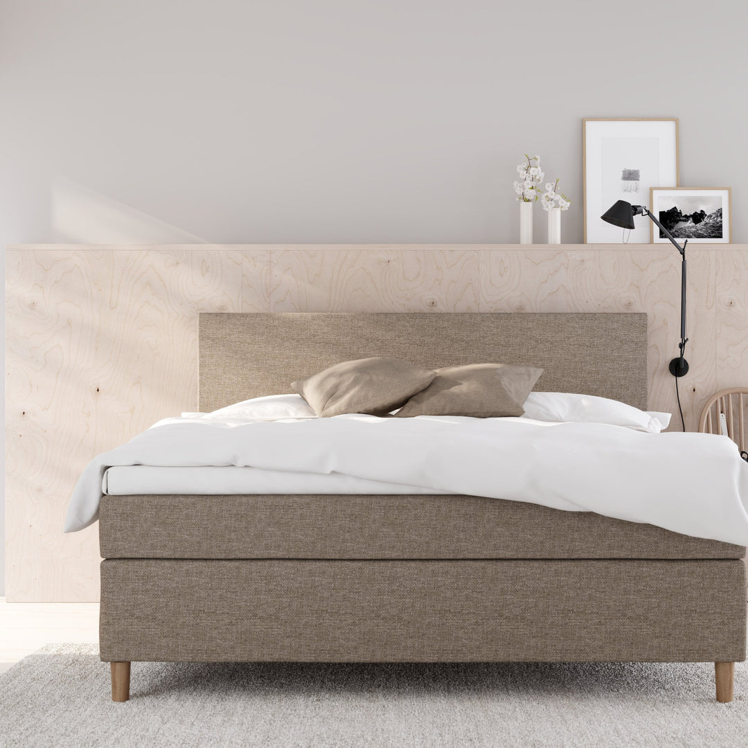 Wonderland Medley kontinentalseng i beige stoff i lyst soverom med finérvegg, hvit dyne og grått teppe