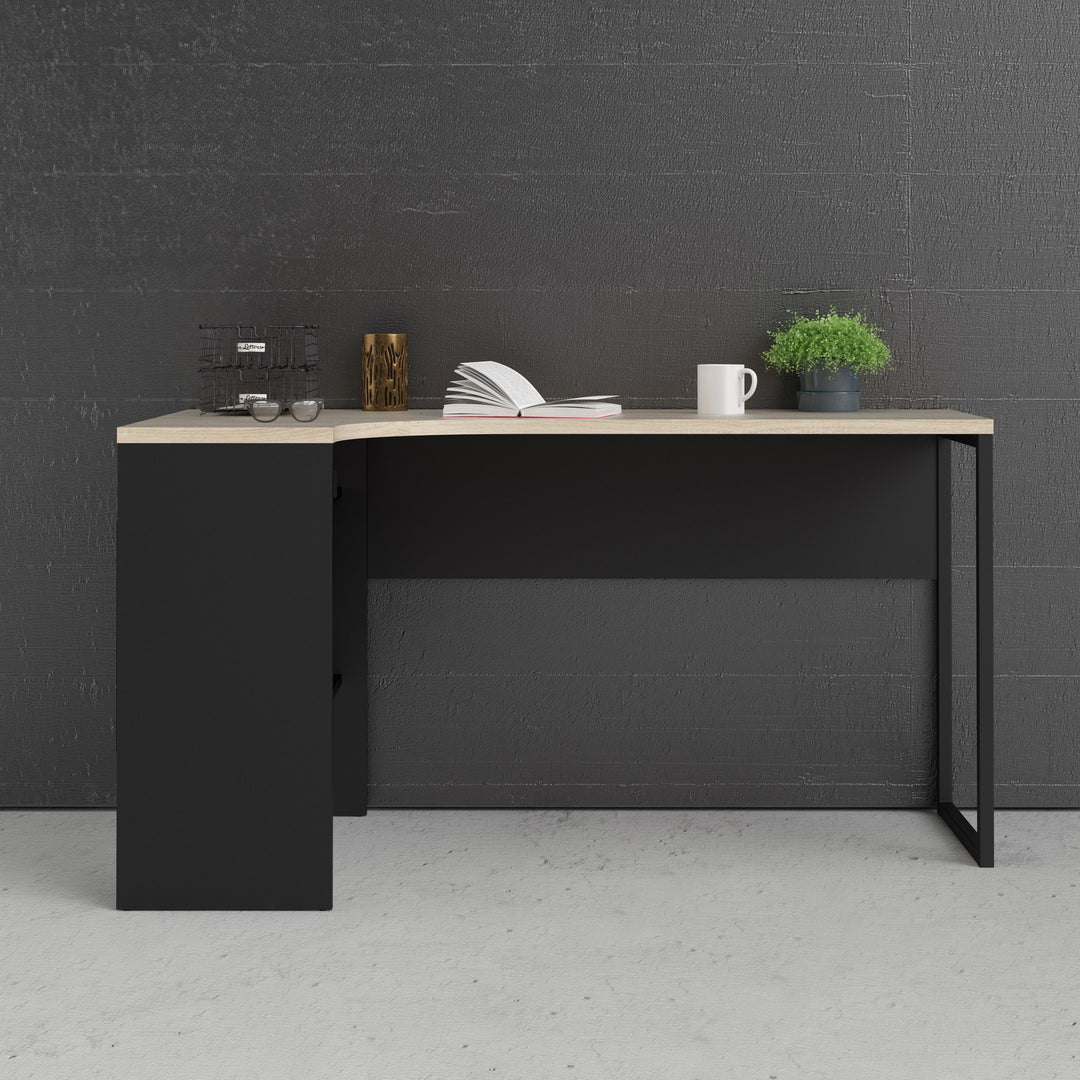 Function Plus skrivebord i sort og eik mot mørk vegg, stylet med plante og bok